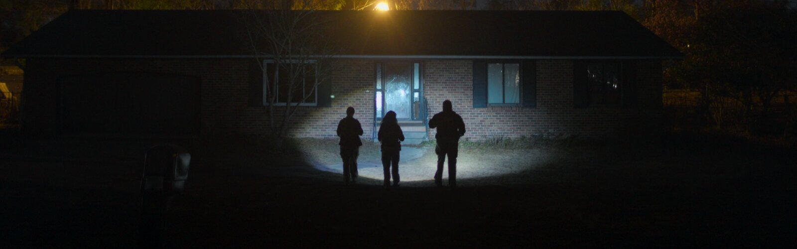 Drei Ermittler*innen aus der neuen Netflix-True-Crime-Serie "Missing: Dead or Alive?" leuchten mit ihren Taschenlampen ein leerstehendes Haus an.