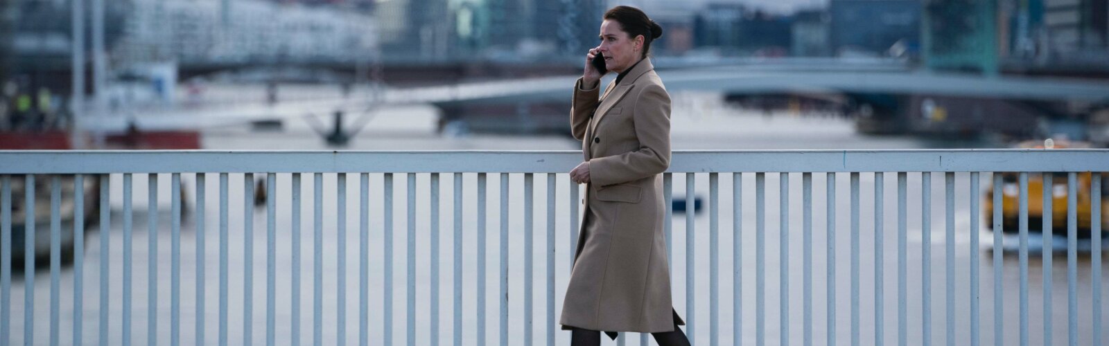 Borgen-Hauptdarstellerin Sidse Babett Knudsen läuft mit einem Handy am Ohr über eine Brücke in Kopenhagen.