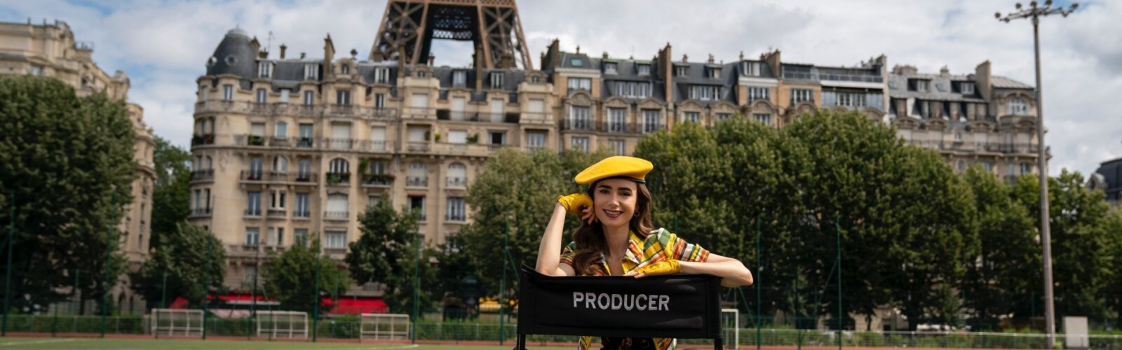 Lily Collins als Produzentin von „Emily in Paris“, im Hintergrund der Eiffelturm.