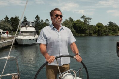 Arnold Schwarzenegger in der Netflix-Serie FUBAR am Steuer eines Motorbootes.