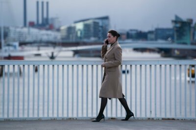Borgen-Hauptdarstellerin Sidse Babett Knudsen läuft mit einem Handy am Ohr über eine Brücke in Kopenhagen.