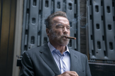Arnold Schwarzenegger in der Netflix-Serie FUBAR mit einer Zigarre im Mund.
