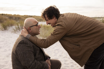 Netflix. Die Liebeskümmerer. Özgür Karadeniz als Turgay und Laurence Rupp als Karl, mit Liebeskummer am Strand.